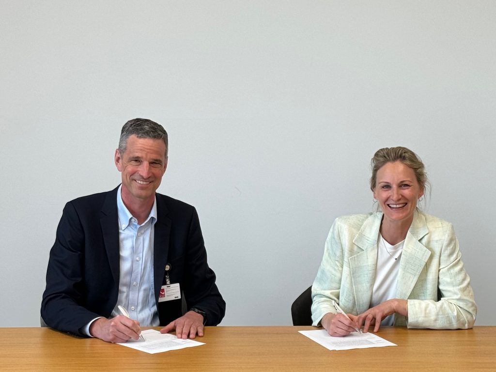 Scott Keeney (left), CEO of nLight, and Marie Langer, CEO of EOS sign the agreement. Photo via EOS.