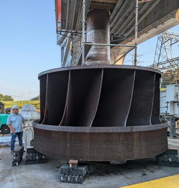 ORNL’s Jay Tiley inspects a hydroelectric runner from TVA’s Cherokee Dam. Photo via Jim Tobin/ORNL, US Dept. of Energy.