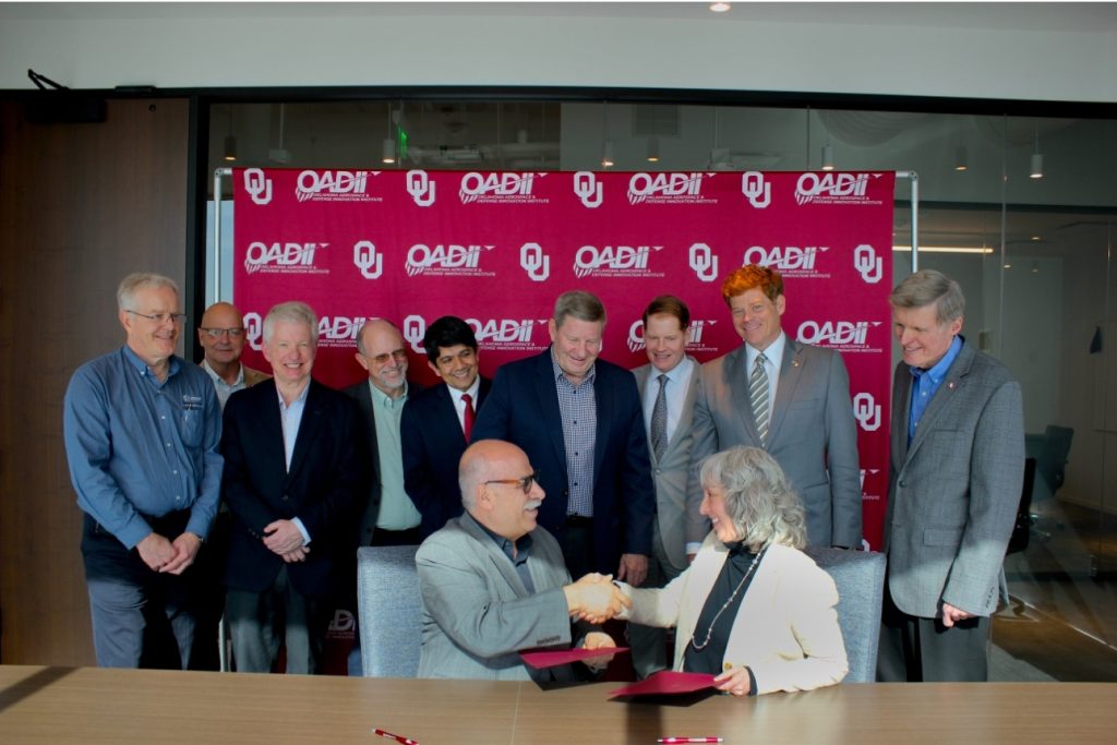 Representatives from the University of Oklahoma (OU) and Oak Ridge National Laboratory (ORNL) reach an agreement. Photo via OU.