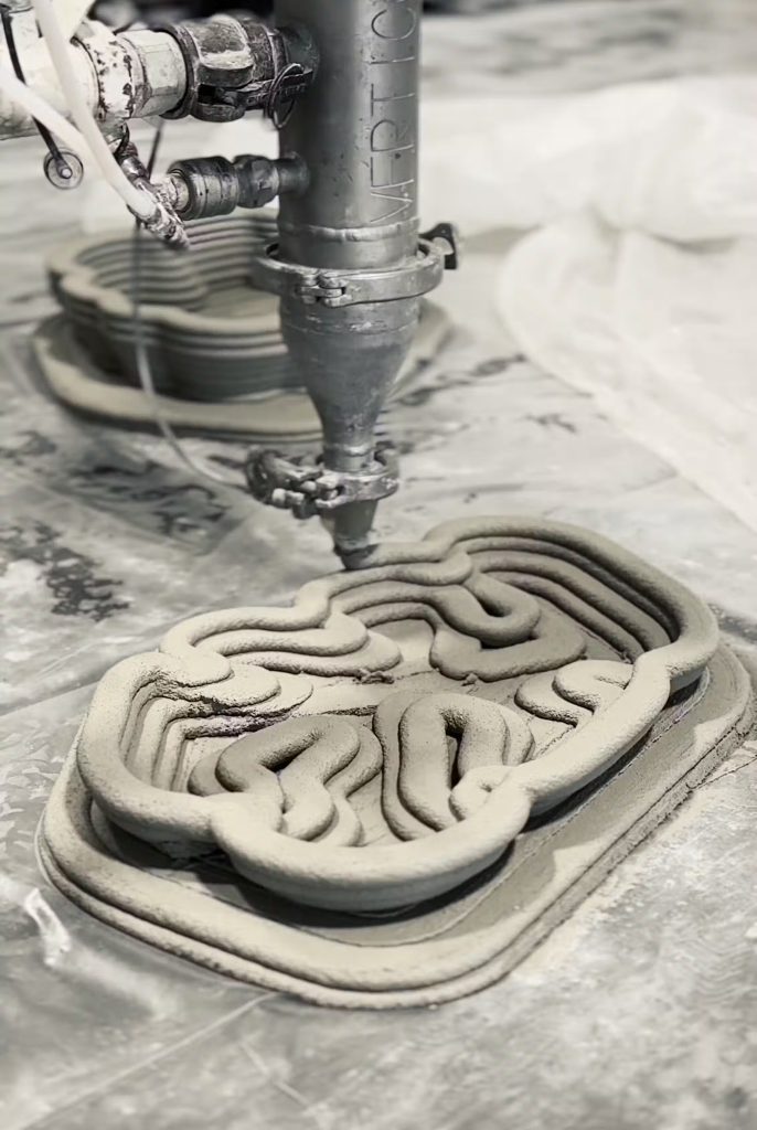A robotic 3D printer extrudes concrete in layered, intricate channels to form BIOCAP tiles. Photo via Sara Pezeshk.
