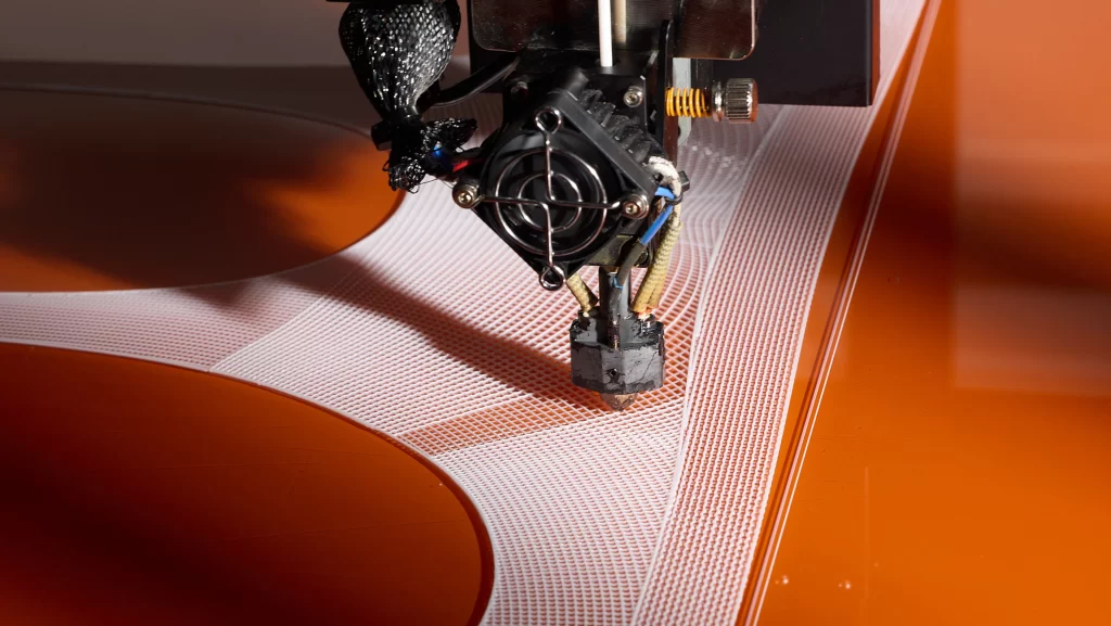 A close-up of the 3D printing process used to manufacture Nike’s FlyWeb fabric. Photo via Nike.
