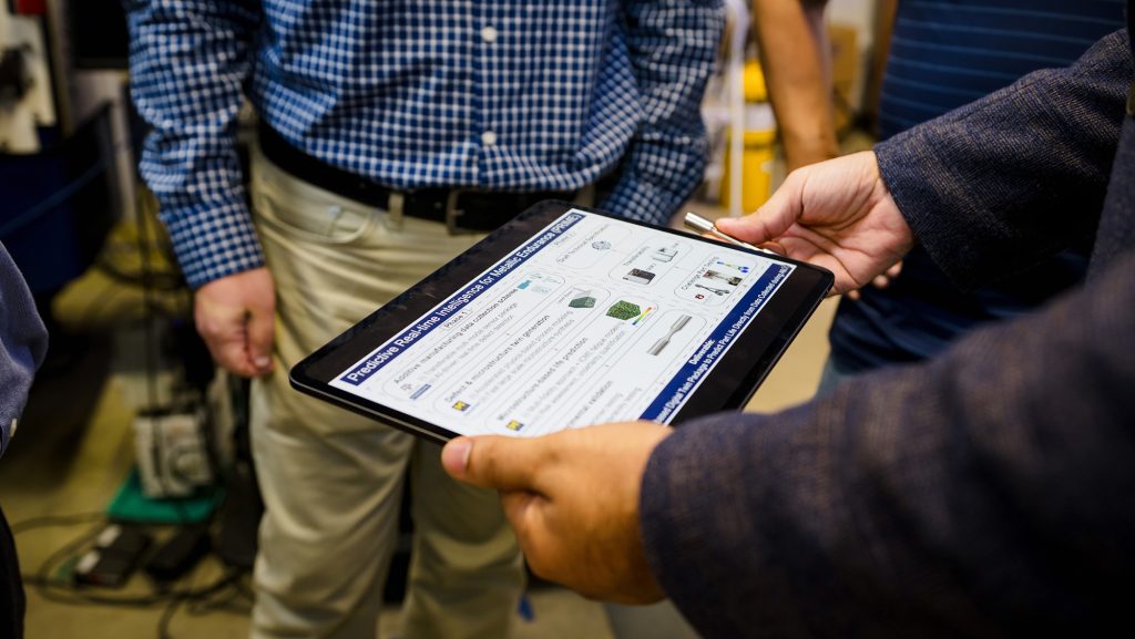 Dr. Mohsen Taheri Andani showing a test sample. Photo via Texas A&M Engineering