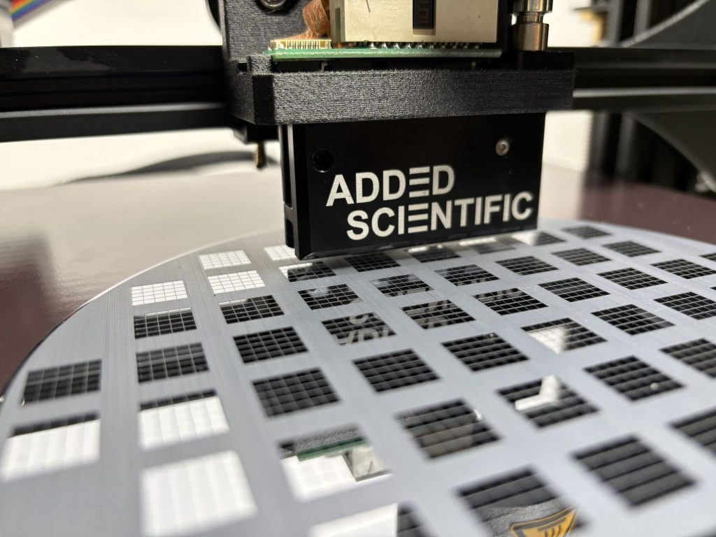 Close-up of the Jetforge printhead assembly during a deposition test. Photo via Added Scientific.