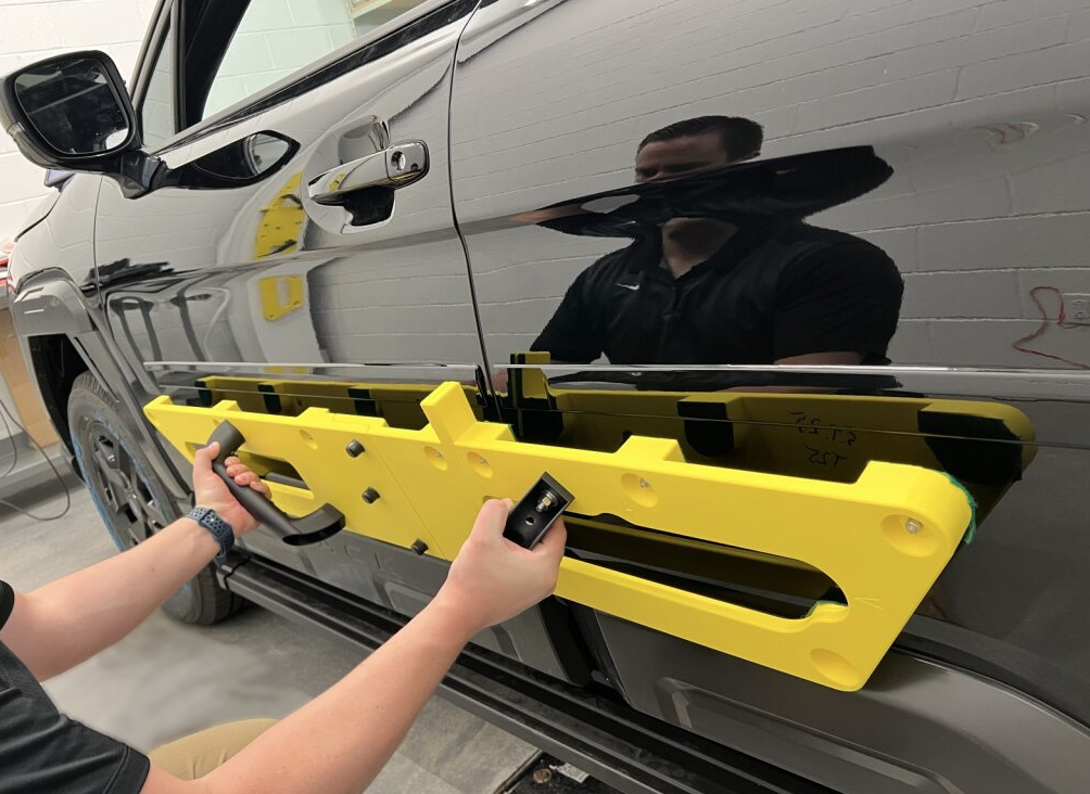 Subaru engineer positioning a 3D printed installation fixture. Photo via Stratasys.